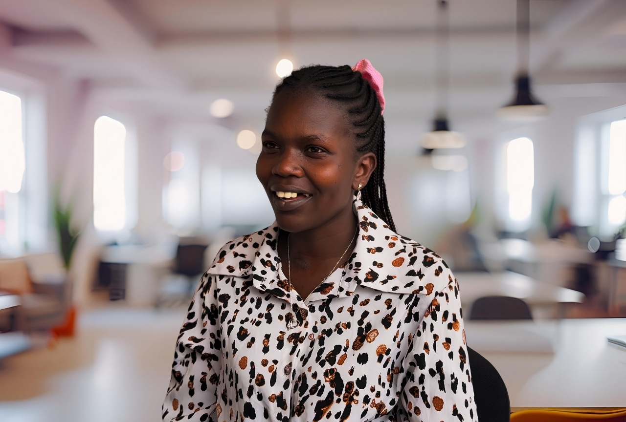 Akol Koor smiling in an open-plan office in Armidale, NSW