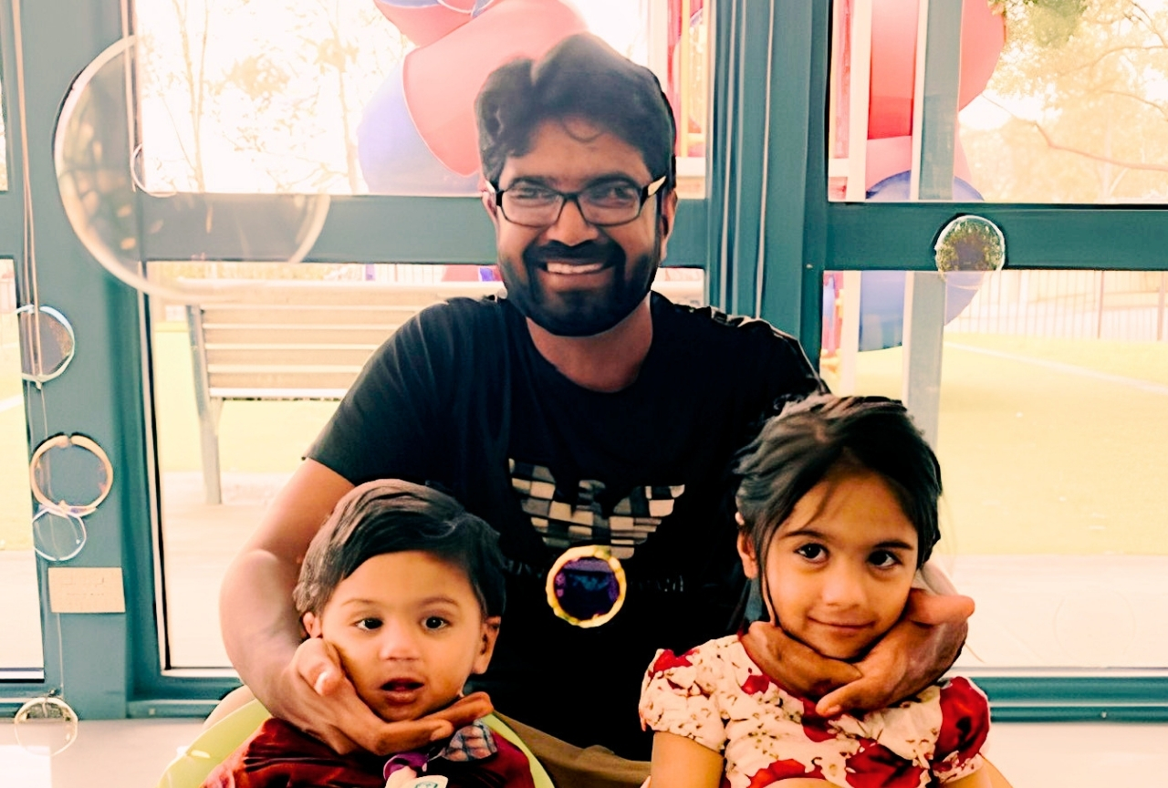 Mansoor Subhani smiling with his two young children, Central Coast NSW