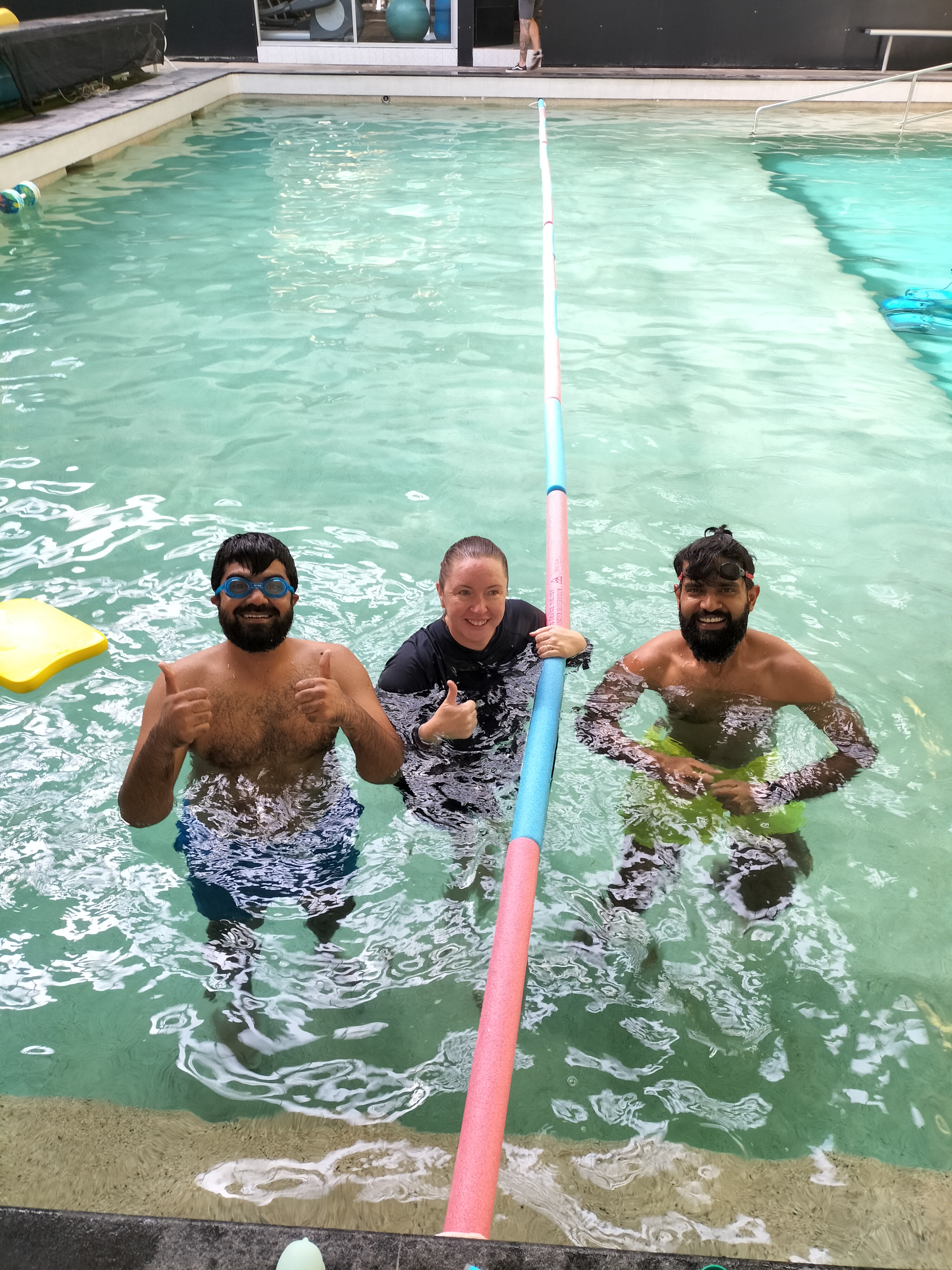 Mansoor with a Mosaic facilitator and another parent in the pool during a PAW swimming course