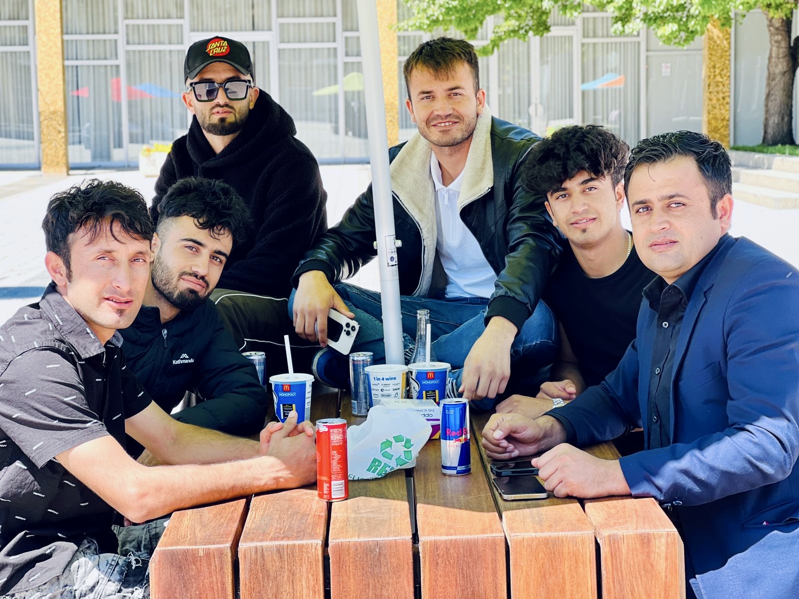 Mustafa with five friends at an outdoor table on a COMPACT trip to Canberra, ACT
