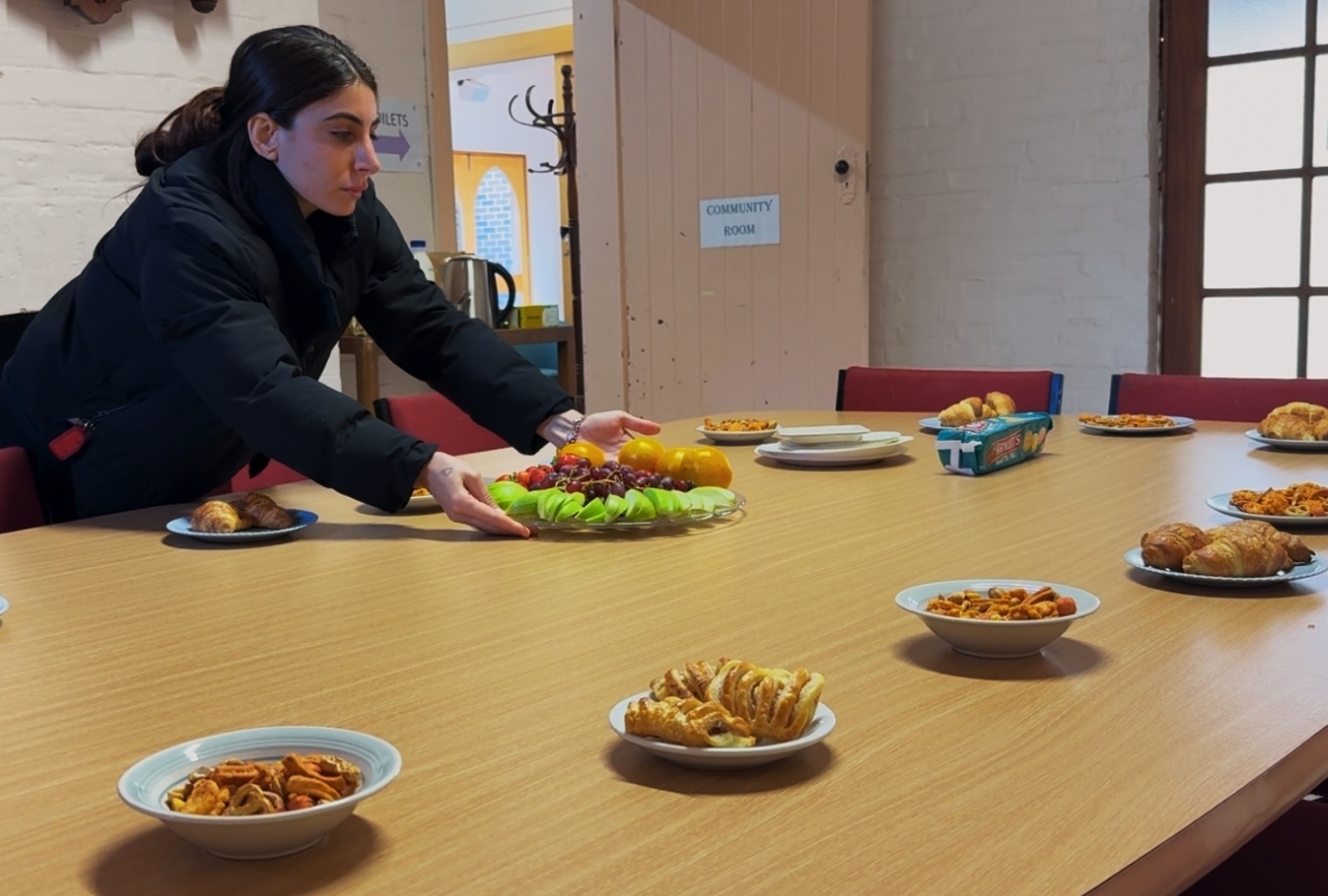 Orien setting up a fruit platter and pastries for the women's group morning tea, Newcastle